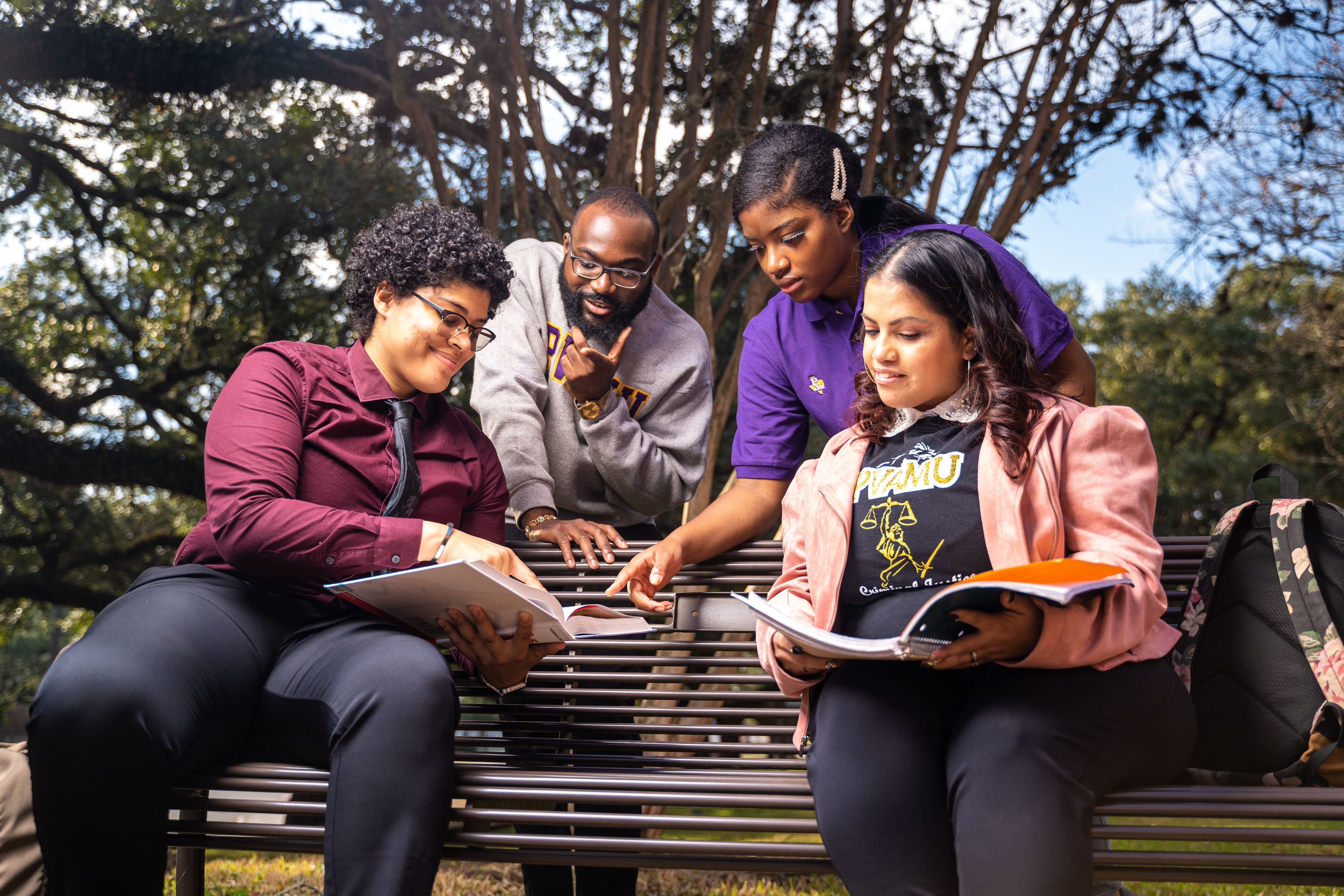 Group of students on bench reading textbooks