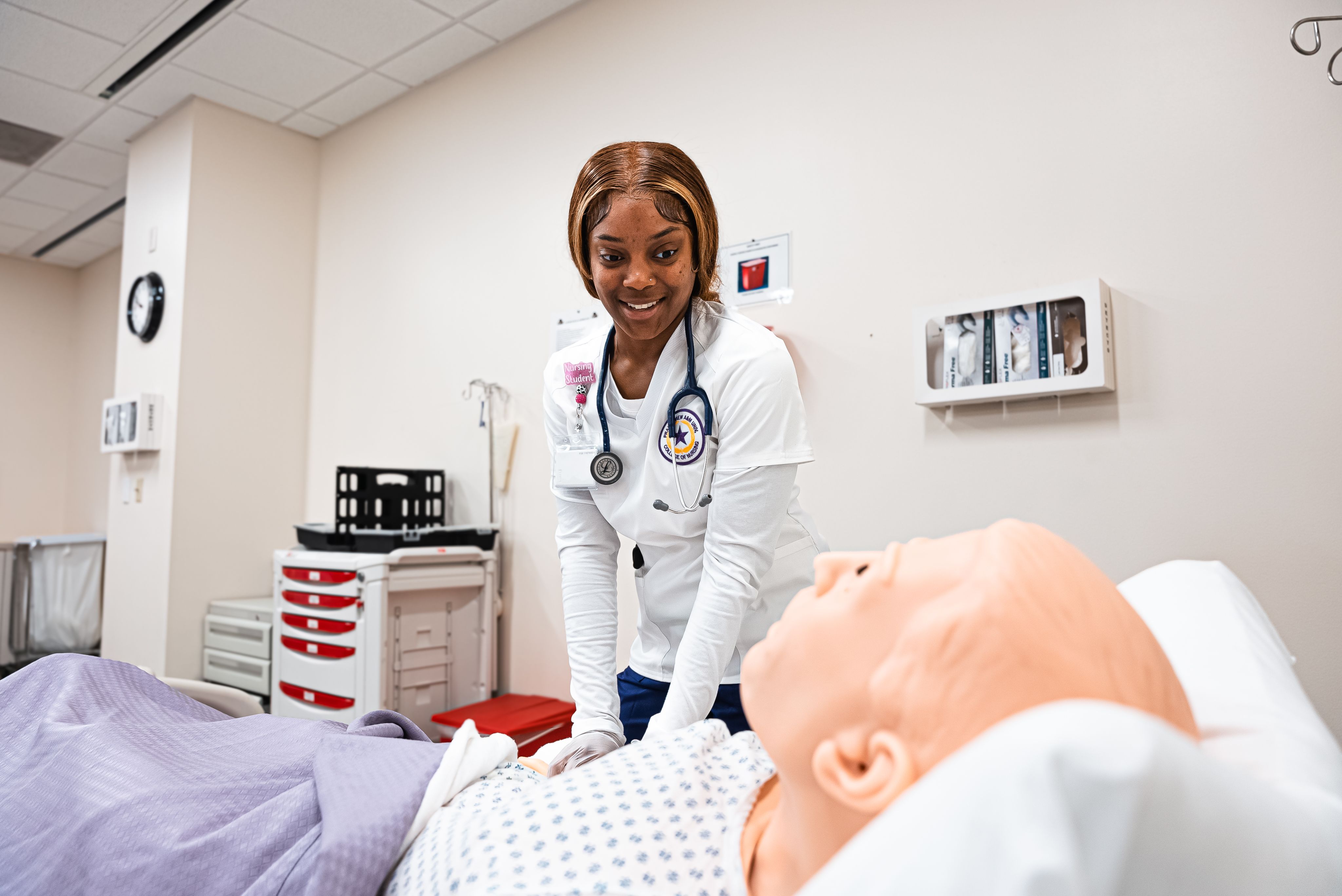 Female nursing student checking vitals on medical dummy