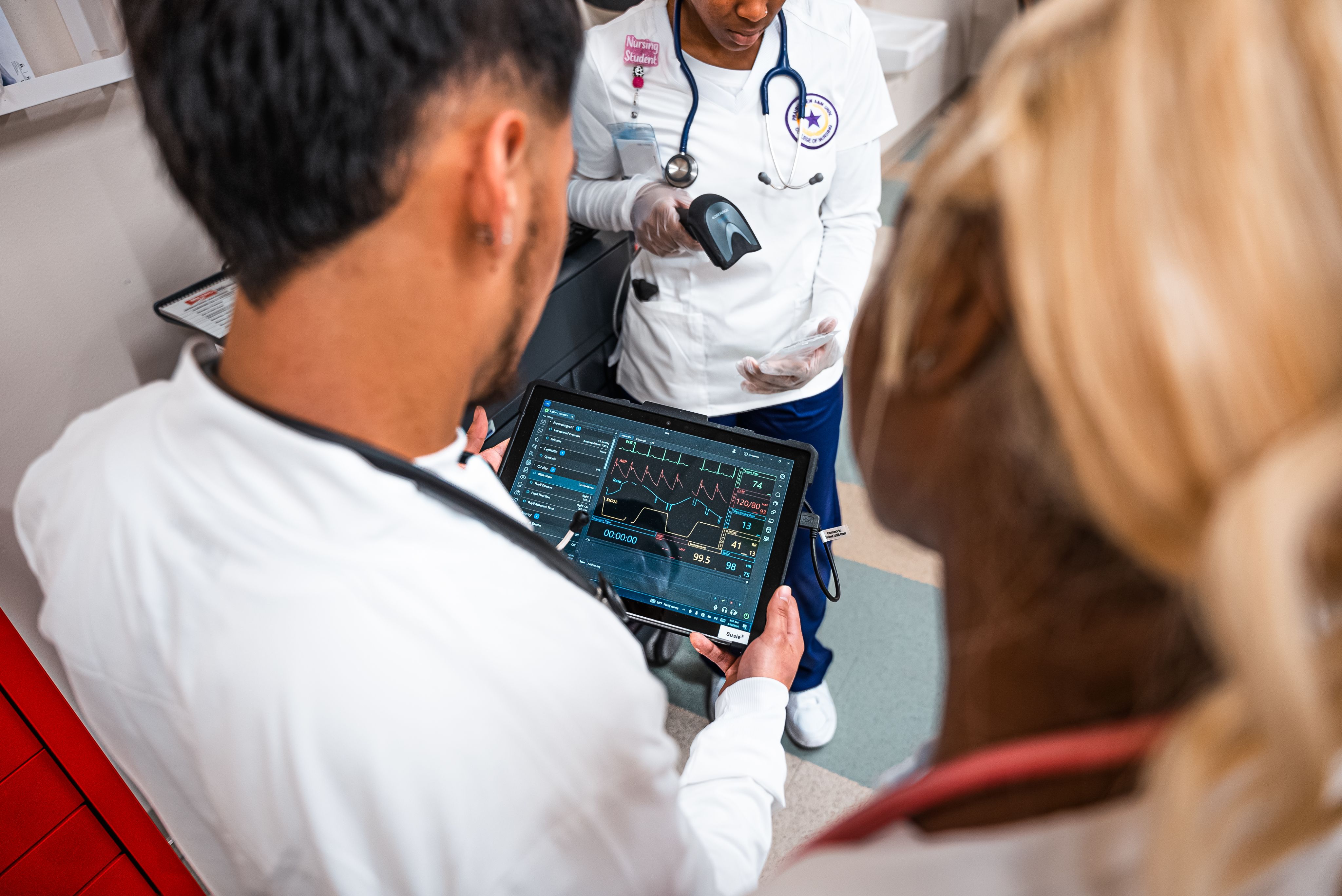 Male nursing student monitoring patient