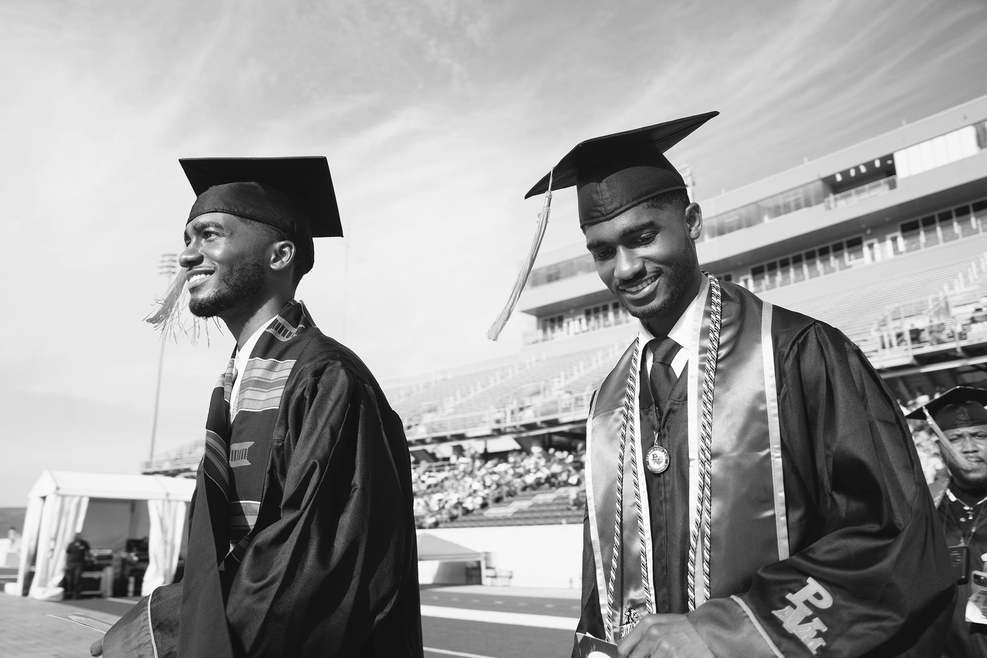Two male graduates walking at a commencement ceremony