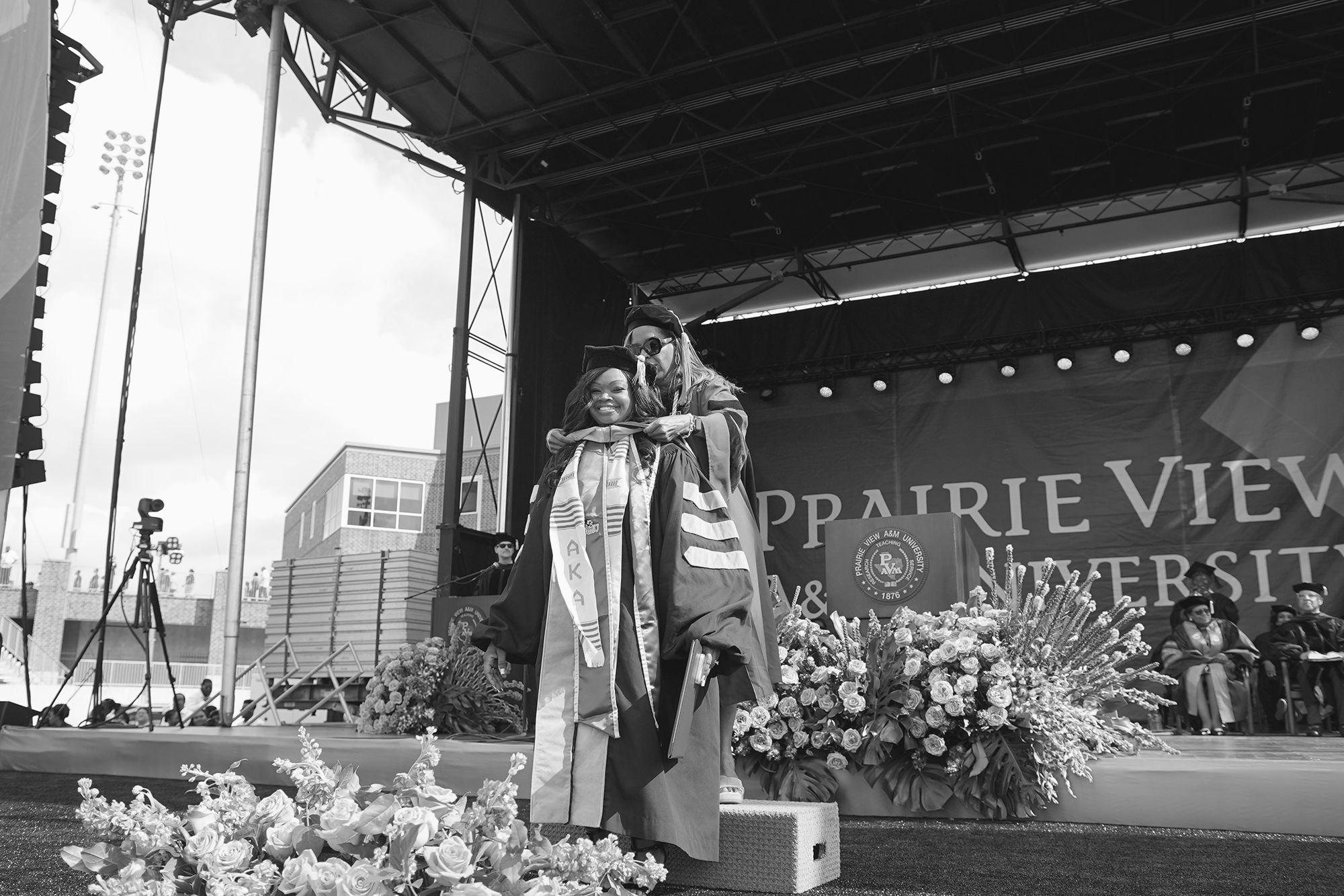 A faculty member placing a doctoral hood over the head of a doctoral candidate